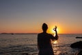 Sithonia - Silhouette of tourist woman with panoramic view of sunset over Aegean Mediterranean Sea on Karydi beach, Greece Royalty Free Stock Photo