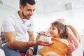 Sits on the chair. Little girl visiting dentist in clinic. Conception of stomatology