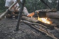 Man sits and heats his feet near the camp fire Royalty Free Stock Photo