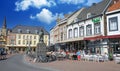 View over square with exterior restaurants and medieval buildings on sunny day