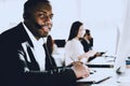 Sitting Afro American Man Working in Call Center. Manager with Computer. Man on Workplace. Consultant with Microphone. Customer Royalty Free Stock Photo