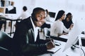 Sitting Afro American Man Working in Call Center. Manager with Computer. Man on Workplace. Consultant with Microphone. Customer Royalty Free Stock Photo