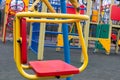 Sitting a baby swing in a deserted empty playground in the city`s recreation park during the coronavirus quarantine period