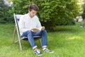 Sitting bearded young adult reading a book in the garden Royalty Free Stock Photo