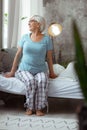 Full-sized photo of dame wearing nightclothes sitting on the bed Royalty Free Stock Photo