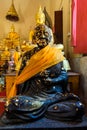 Sitting Black Buddha statue with gold leaf Royalty Free Stock Photo