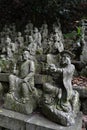 The Sitting Buddha between hundreds of Buddha statues of Japanese style