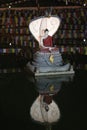 Sitting buddha sculpture protecting by giant master of serpent statue in the middle of claim river at India