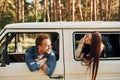 Sitting in the car. Young couple is traveling in the forest at daytime together Royalty Free Stock Photo