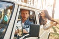 Sitting in the car. Young couple is traveling in the forest at daytime together Royalty Free Stock Photo