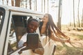 Sitting in the car. Young couple is traveling in the forest at daytime together Royalty Free Stock Photo