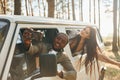 Sitting in the car. Young couple is traveling in the forest at daytime together Royalty Free Stock Photo