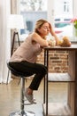 Blond-haired woman sitting on chair and looking at allergic foods