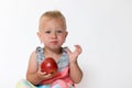 Sitting cool toddler girl is holding red apple Royalty Free Stock Photo