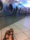 Sitting Crossed Ankles on Floor of Laundromat