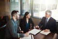 Sitting down to discuss the details. High angle shot of three businesspeople working in the boardroom. Royalty Free Stock Photo