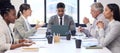 Sitting down to finalise matters. a young businessman using a laptop during a meeting with his colleagues in an office. Royalty Free Stock Photo