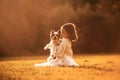 Sitting on the grass. Cute little girl is on the field with dog Royalty Free Stock Photo