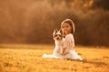 Sitting on the grass. Cute little girl is on the field with dog Royalty Free Stock Photo