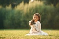 Sitting on the grass. Cute little girl is on the field with dog Royalty Free Stock Photo