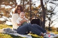 Sitting on the ground. Beautiful mother with her little son is outdoors in the forest Royalty Free Stock Photo