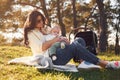 Sitting on the ground. Beautiful mother with her little son is outdoors in the forest Royalty Free Stock Photo