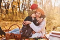 Sitting on the ground. Mother with her little son and daughter is having fun in the autumn park Royalty Free Stock Photo