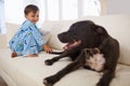 Sitting with his best friend. A cute liittle boy sitting on a couch with his dog.