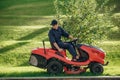 Sitting on the lawn mover. Professional gardener is on the lawn Royalty Free Stock Photo