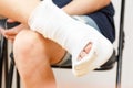 Sitting man leg injury plaster, ankle