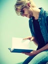 Sitting man reading book outside on sunny day Royalty Free Stock Photo