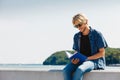 Sitting man reading book outside on sunny day Royalty Free Stock Photo