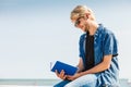 Sitting man reading book outside on sunny day Royalty Free Stock Photo