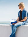 Sitting man reading book outside on sunny day Royalty Free Stock Photo