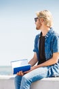 Sitting man reading book outside on sunny day Royalty Free Stock Photo