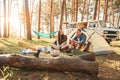 Sitting near the tent. Young couple is traveling in the forest at daytime together Royalty Free Stock Photo