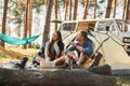 Sitting near the tent. Young couple is traveling in the forest at daytime together Royalty Free Stock Photo