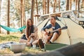 Sitting near the tent. Young couple is traveling in the forest at daytime together Royalty Free Stock Photo