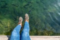 Sitting on the pier and looking to a flock of Trout fish in a lake.