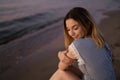 Sitting: Portrait of a Beautiful blonde woman in a light blue dress on the Baltic Sea beach during sunset with vivid Royalty Free Stock Photo