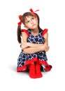 Sitting sad, thoughtful child girl with red bows, isolated on wh