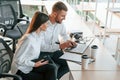 Sitting by the table with laptop. Man and woman are working in the modern office together Royalty Free Stock Photo