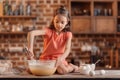 Sitting on table and mixing ingredients for dough for cake