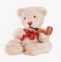 Sitting teddy bear with red bow and wooden pipe Royalty Free Stock Photo