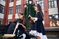 Sitting together. Two schoolgirls is outside near school building Royalty Free Stock Photo