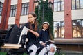 Sitting together. Two schoolgirls is outside near school building Royalty Free Stock Photo