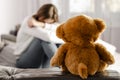 Sitting upset woman and teddy bear. Selective focus. Loneliness concept Royalty Free Stock Photo