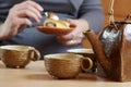 Sitting woman eating her dessert with a spoon at a cup of tea an