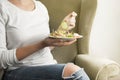 Sitting woman hold and eating vegan salad with arugula, celery and spinach in white plate. Healthy eating Royalty Free Stock Photo