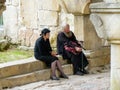 Sitting women with a priest in the entrance of the orthodox monastery of Gelati in Georgia.